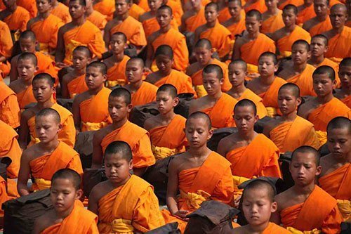 Group of young buddhists monks meditating